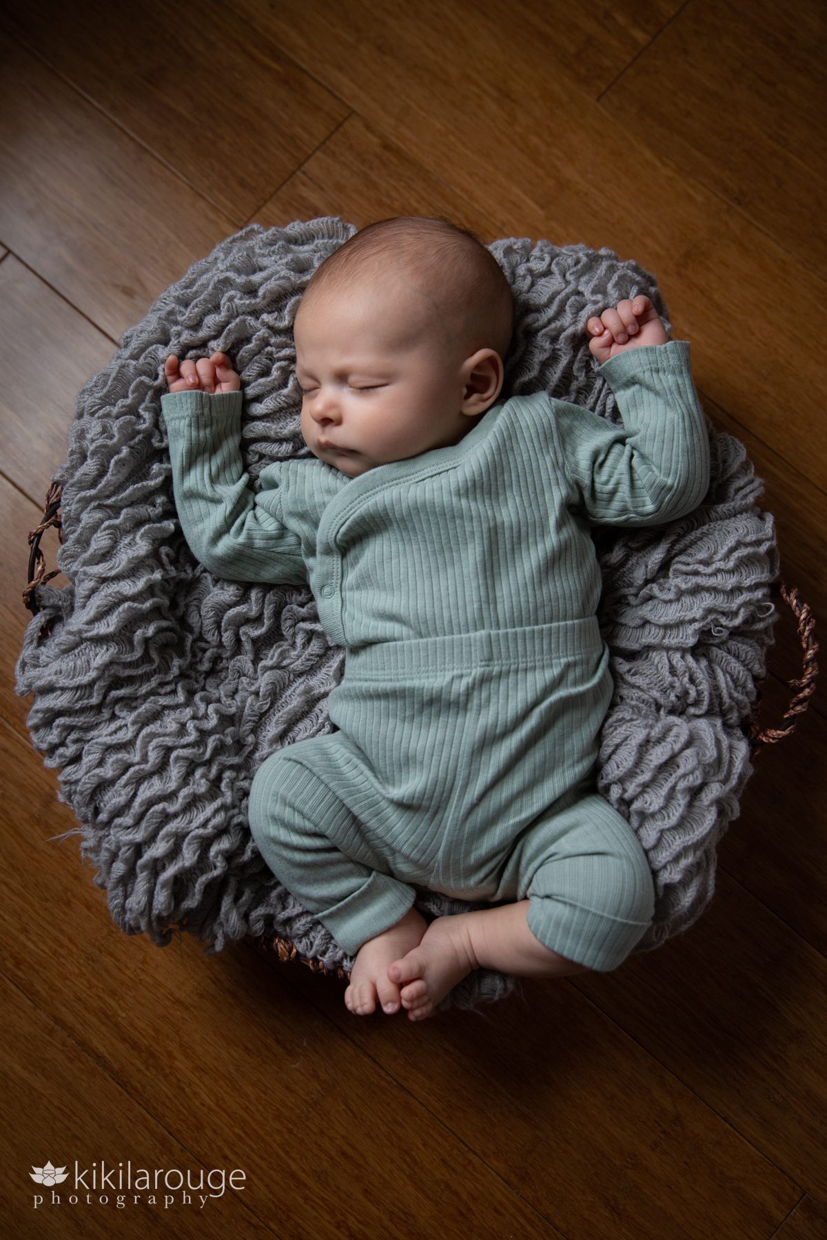Sleeping baby in a basket with gray blanket
