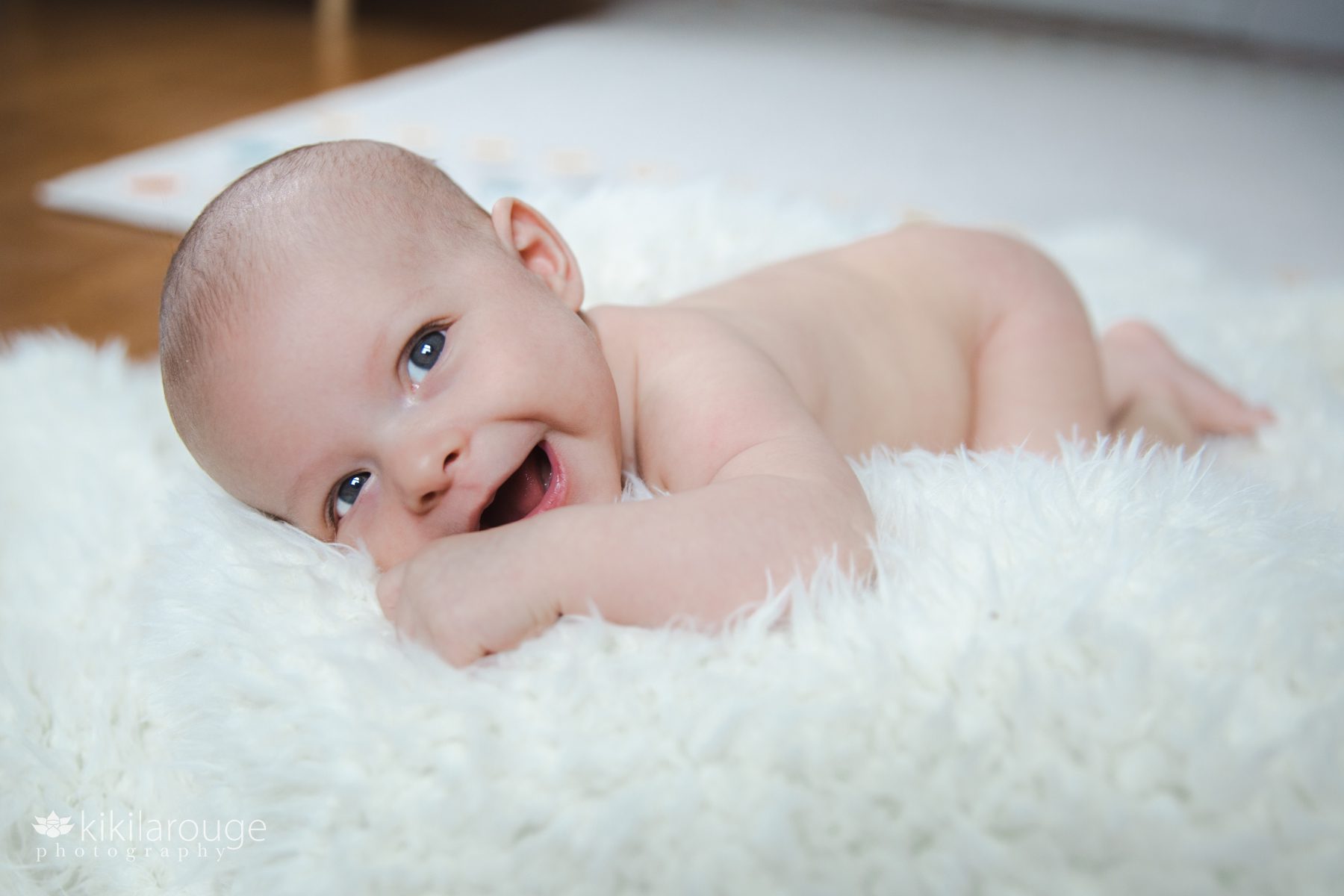 Naked Smiling baby in plush white blanket