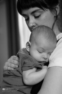 Mom snuggling with sleeping baby in her arms