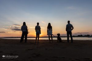 Silhouette of a family of four with their dog at sunset at Plum Island Beach