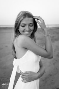 Teen girl portrait in white dress looking down and smiling
