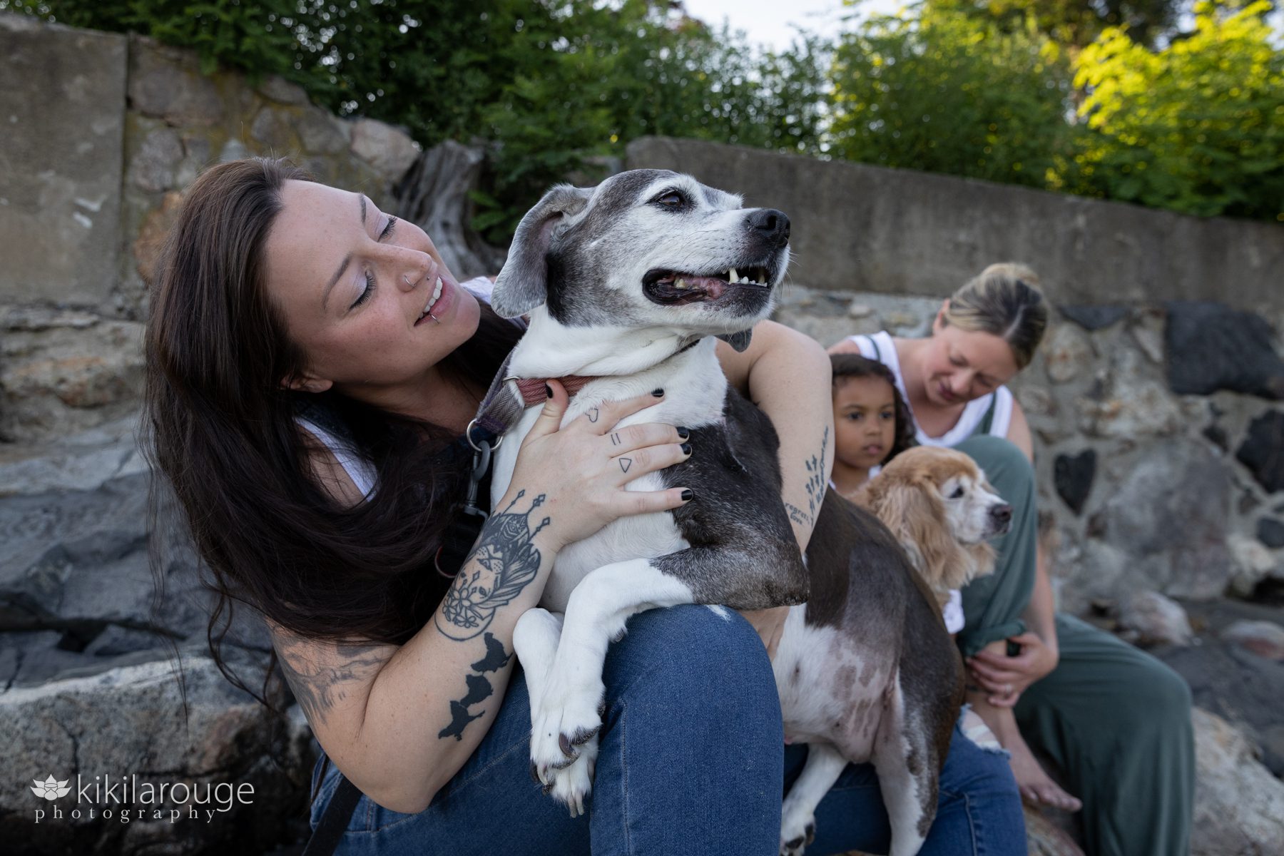 Woman hugging her Senior Rescue Dog with family in background