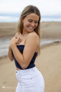 Senior girl portrait looking down in white jeans