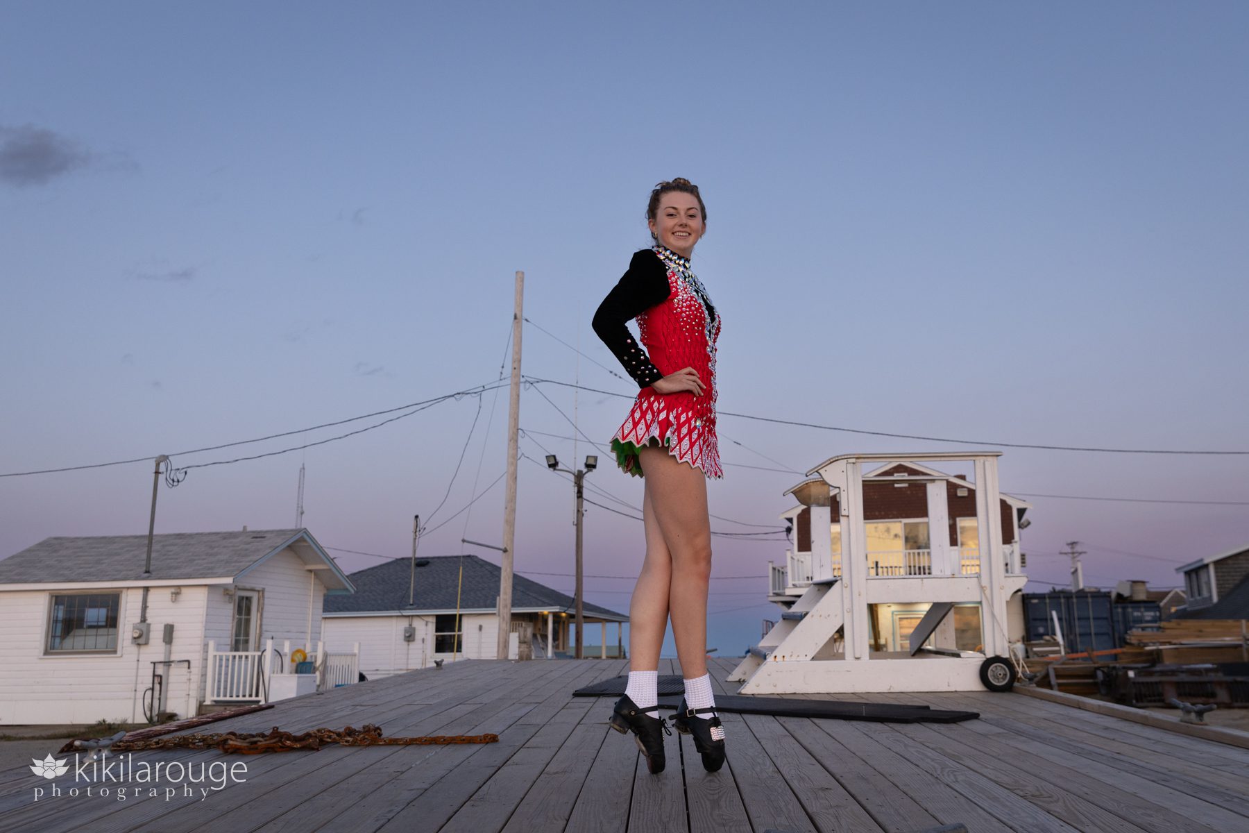 Girl in Irish Step Dancing dress and shoes on top of high platform at beach at sunset Plum Island