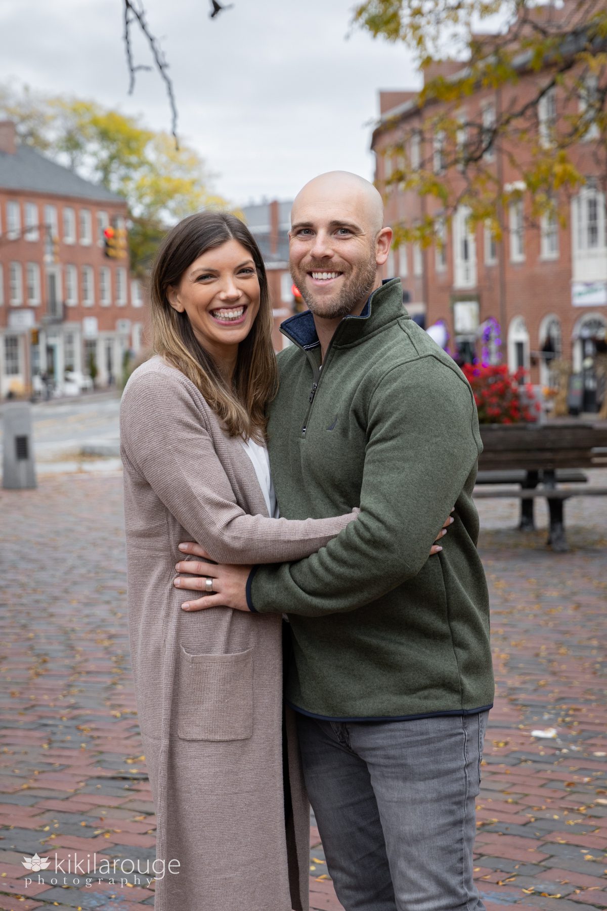 Cute 30 something couple in Newburyport square surround by brick backdrops