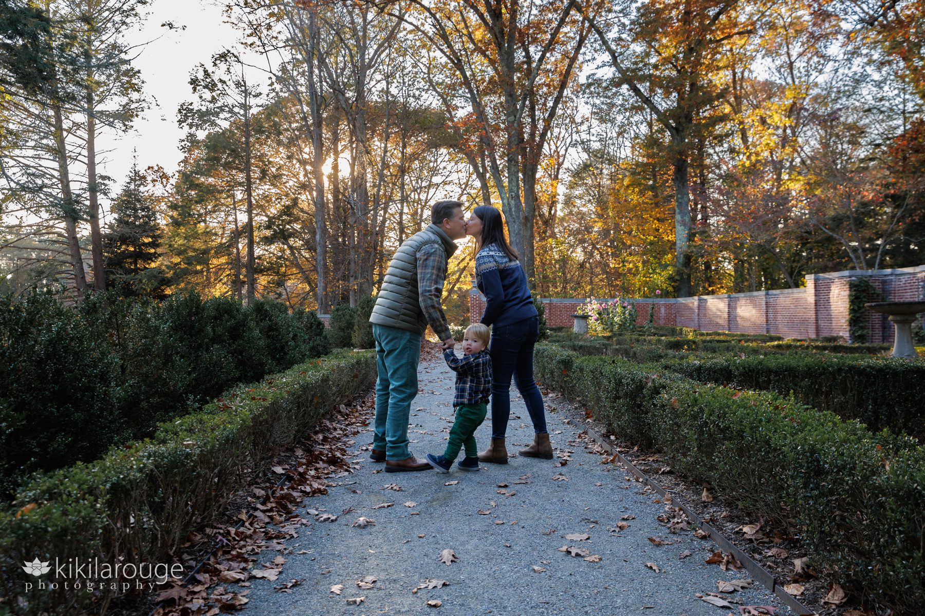 Couple kissing park with toddler son holding hands