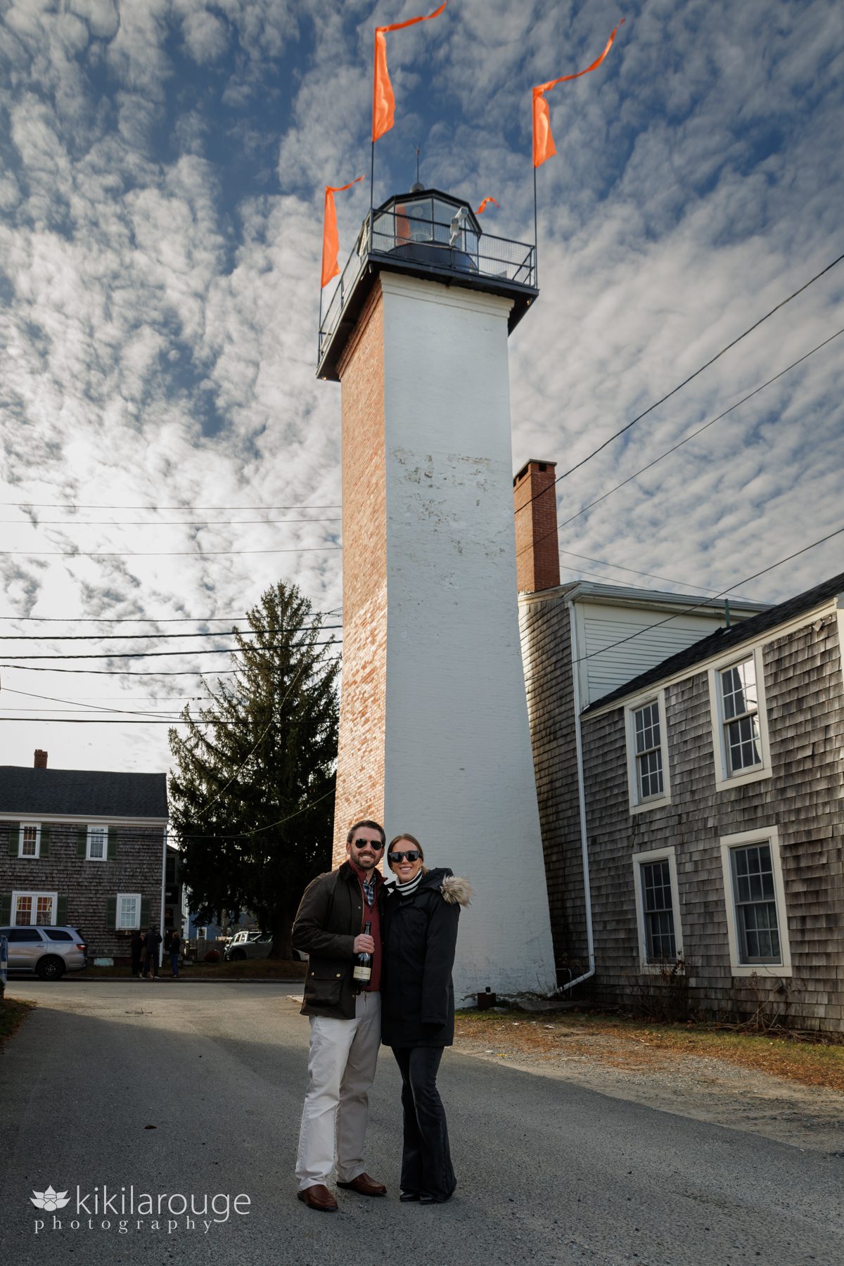 Couple in front of the NBPT lighthouse with dramatic clouds in the sky