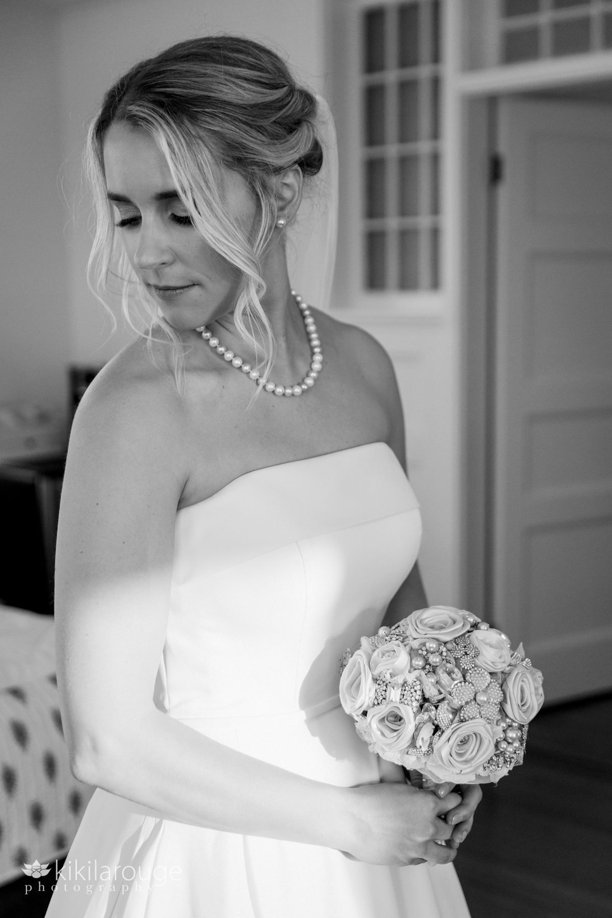 BW Bridal Portrait holding bouquet looking down side