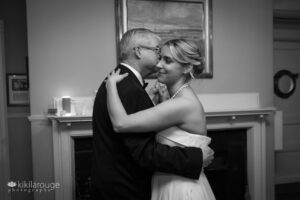 Father and daughter wedding dance at yacht club in front of fireplace