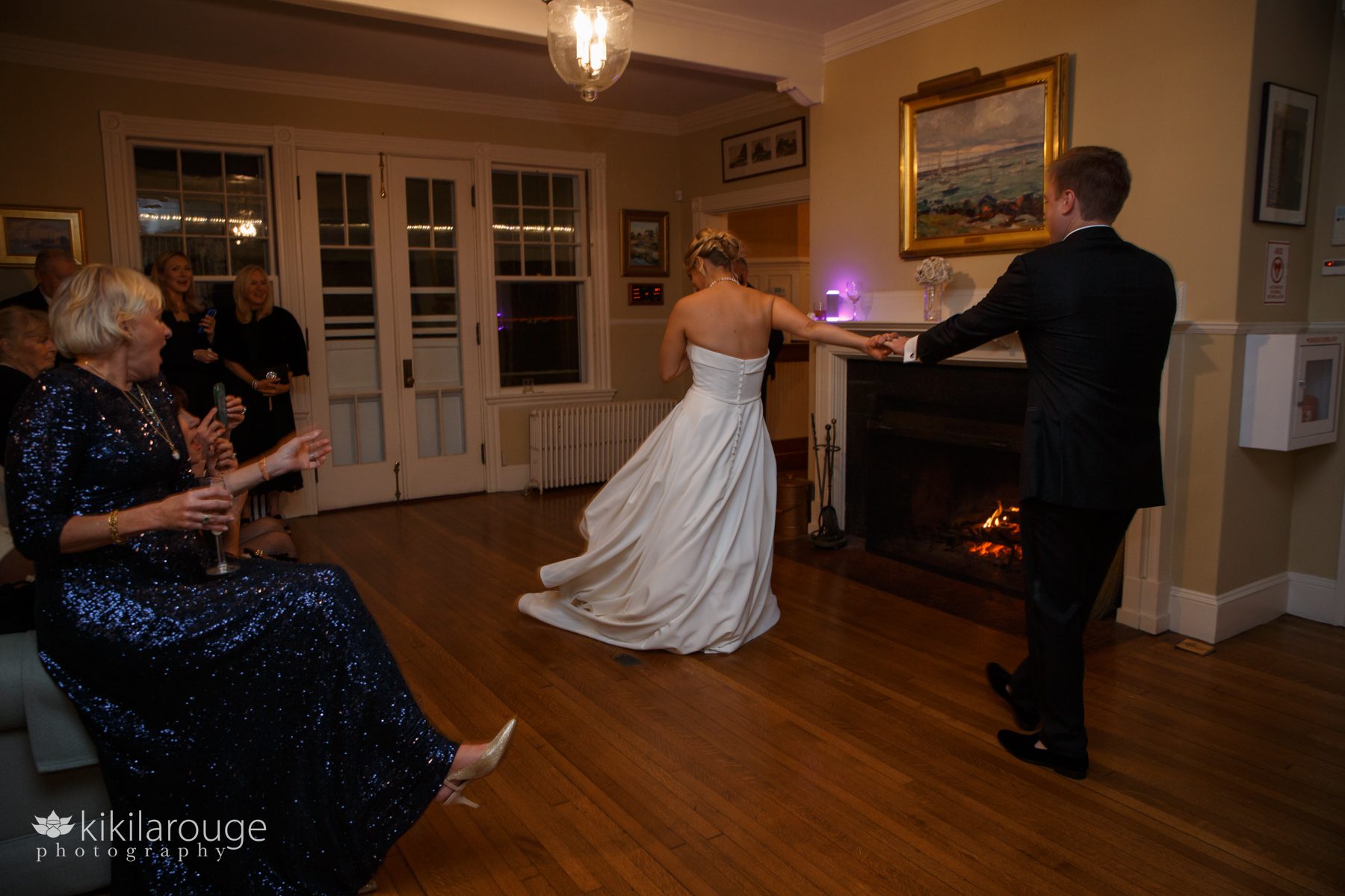 Wedding couple first dance twirling with family celebrating