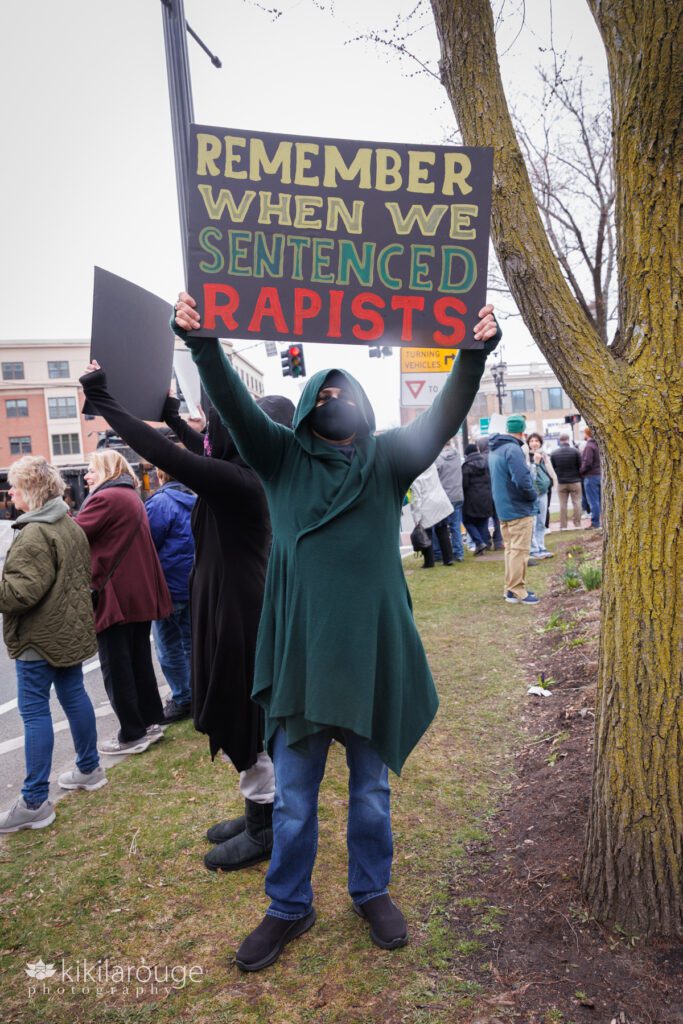 Hands Off Rally Salem Ma with person in jeans and black mask holding protest sign