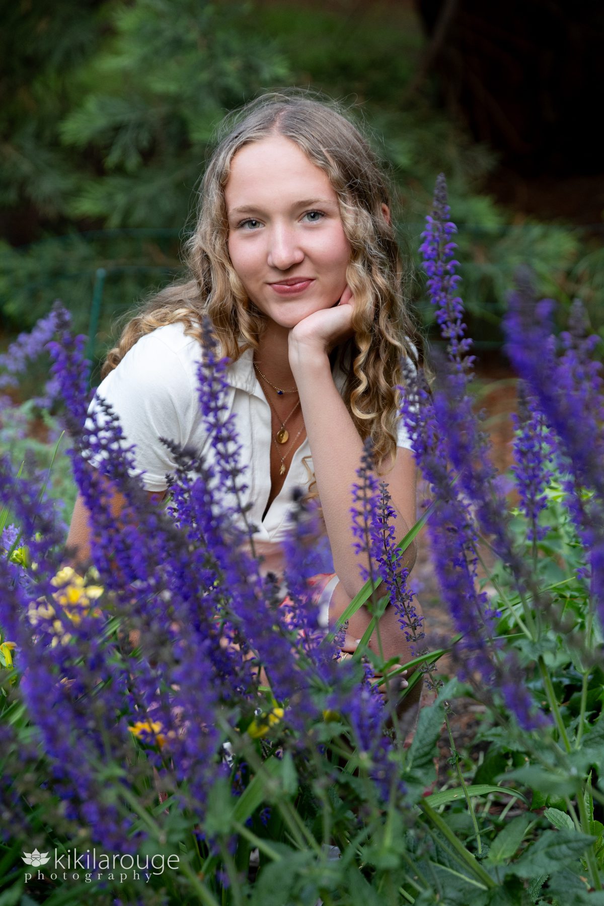 Senior Portrait of girl with blonde curly hair in the middle of purple wild flowers Jack Block park West Seattle WA