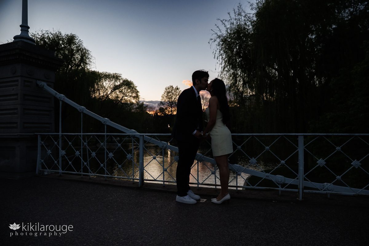Couple in silhouette at sunset kissing on the bridge in Boston's Public Garden