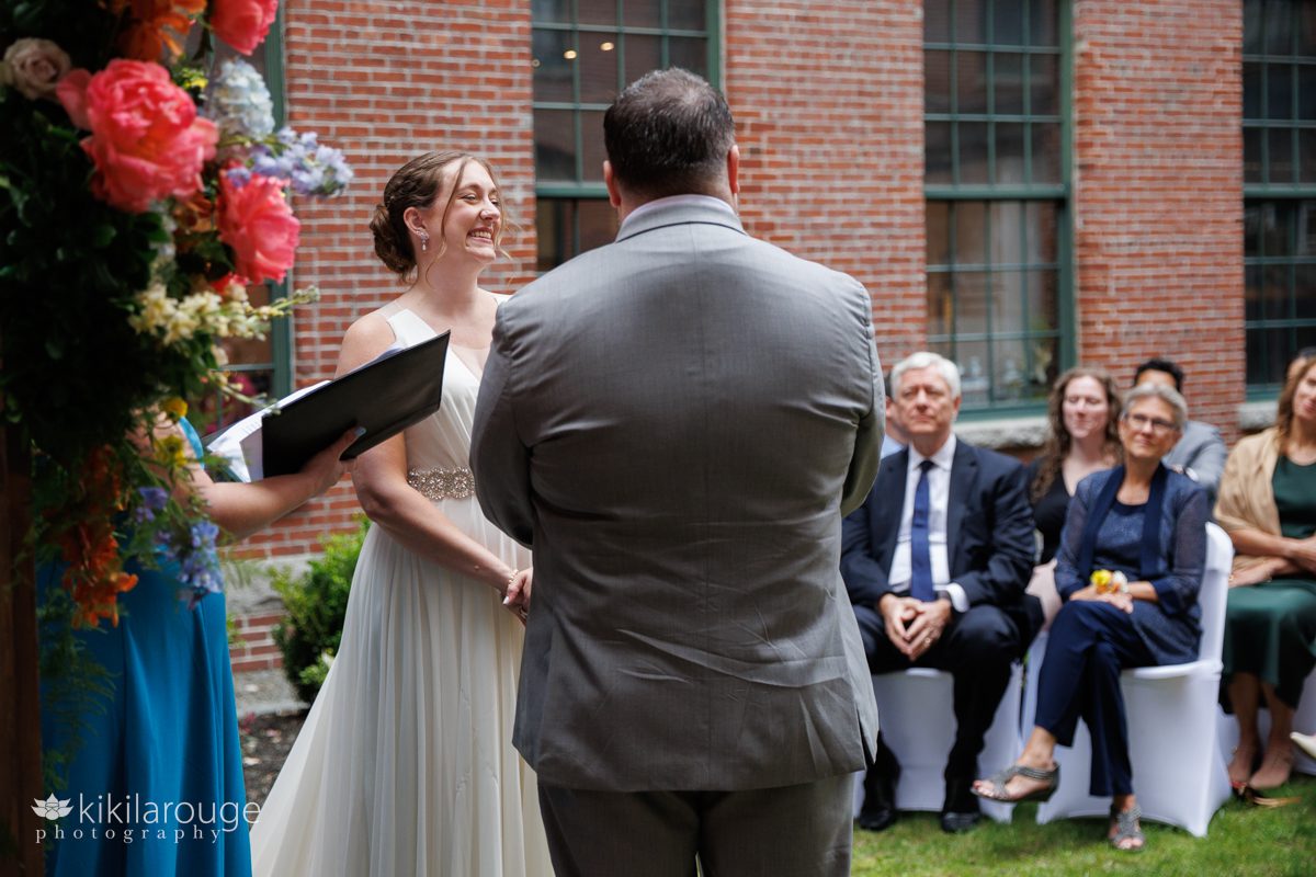 Couple at altar bride laughing with her parents in backdrop 