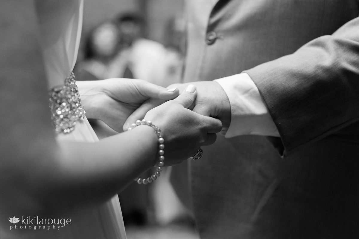 Close up of couple's hands at the altar as they exchange rings