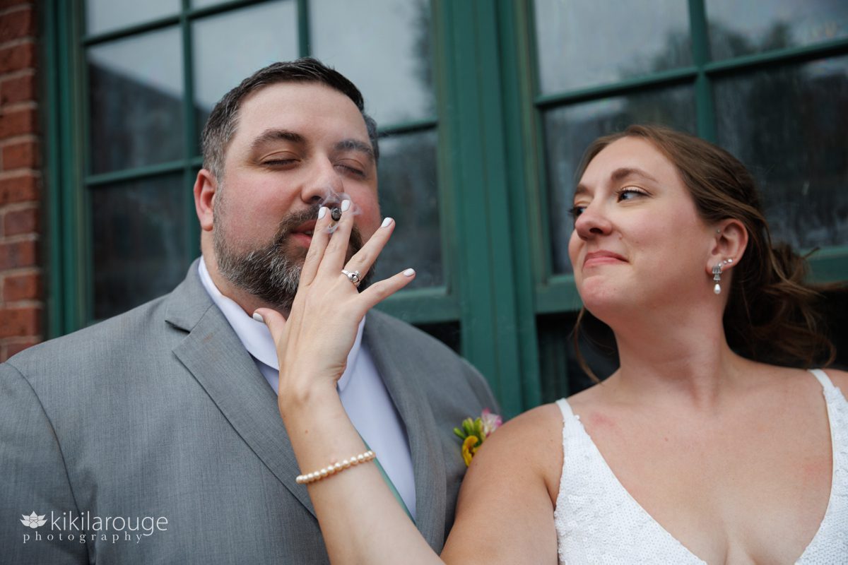 Couple on their wedding day smoking bride holding the blunt and man with eyes closed inhaling and smoke around 