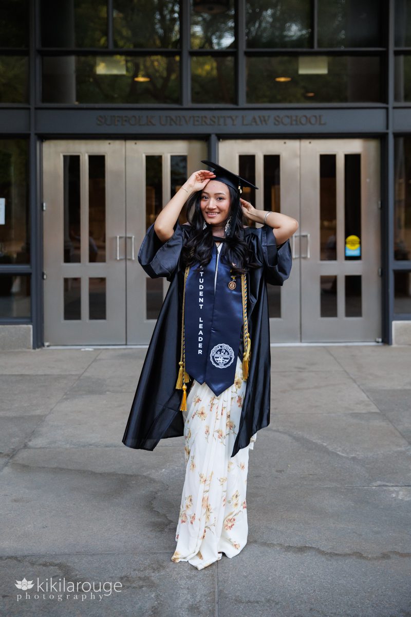 Women dressed in floral yellow sari in blue cap and gown in front to the Suffolk University Law School building in Boston 
