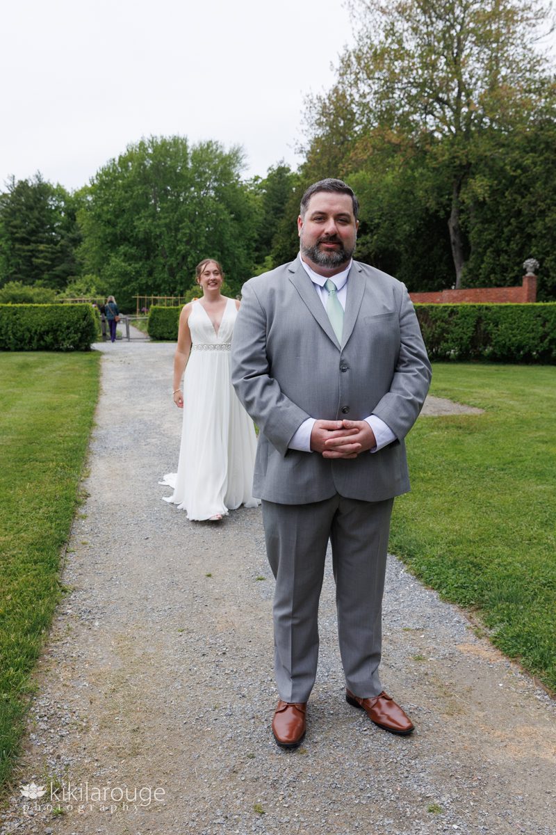 Bride walking up to her groom facing different way for their wedding day first look at Stevens Coolidge gardens