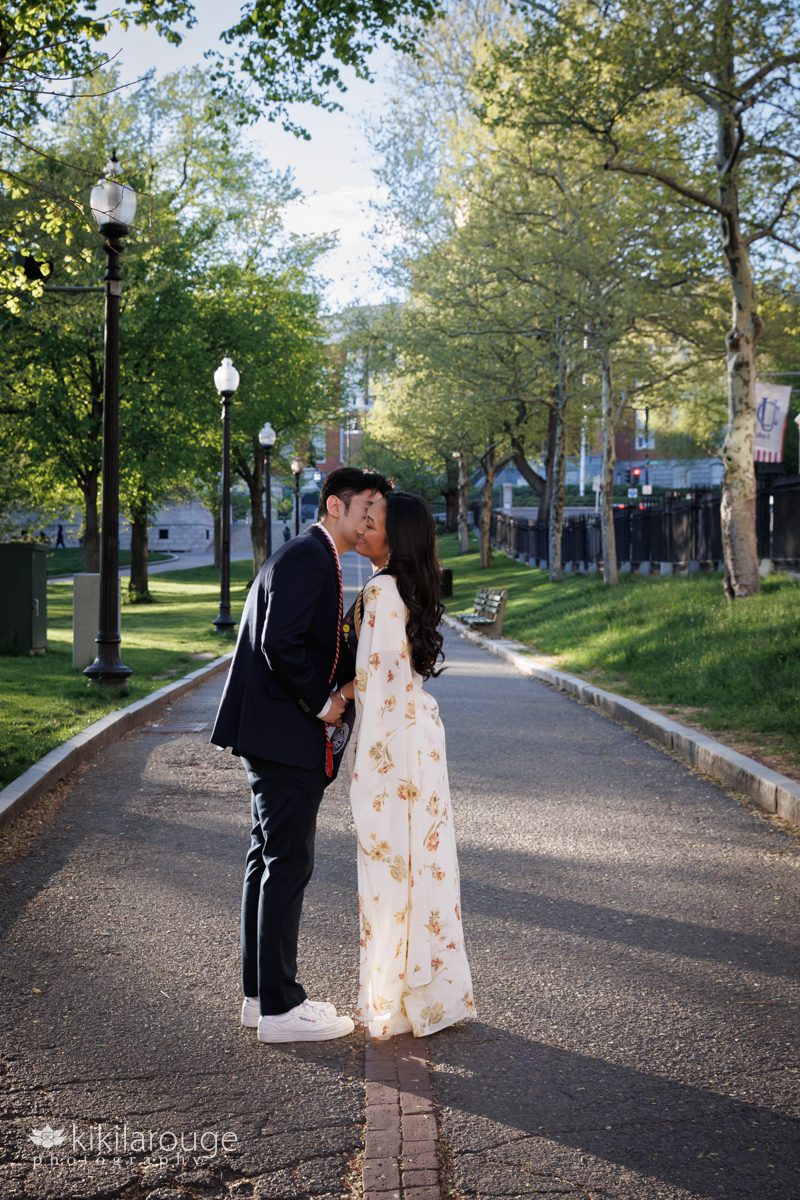 Cute couple with woman in floral yellow sari kissing on the Freedom Trail in Boston Common in front of the Mass State House