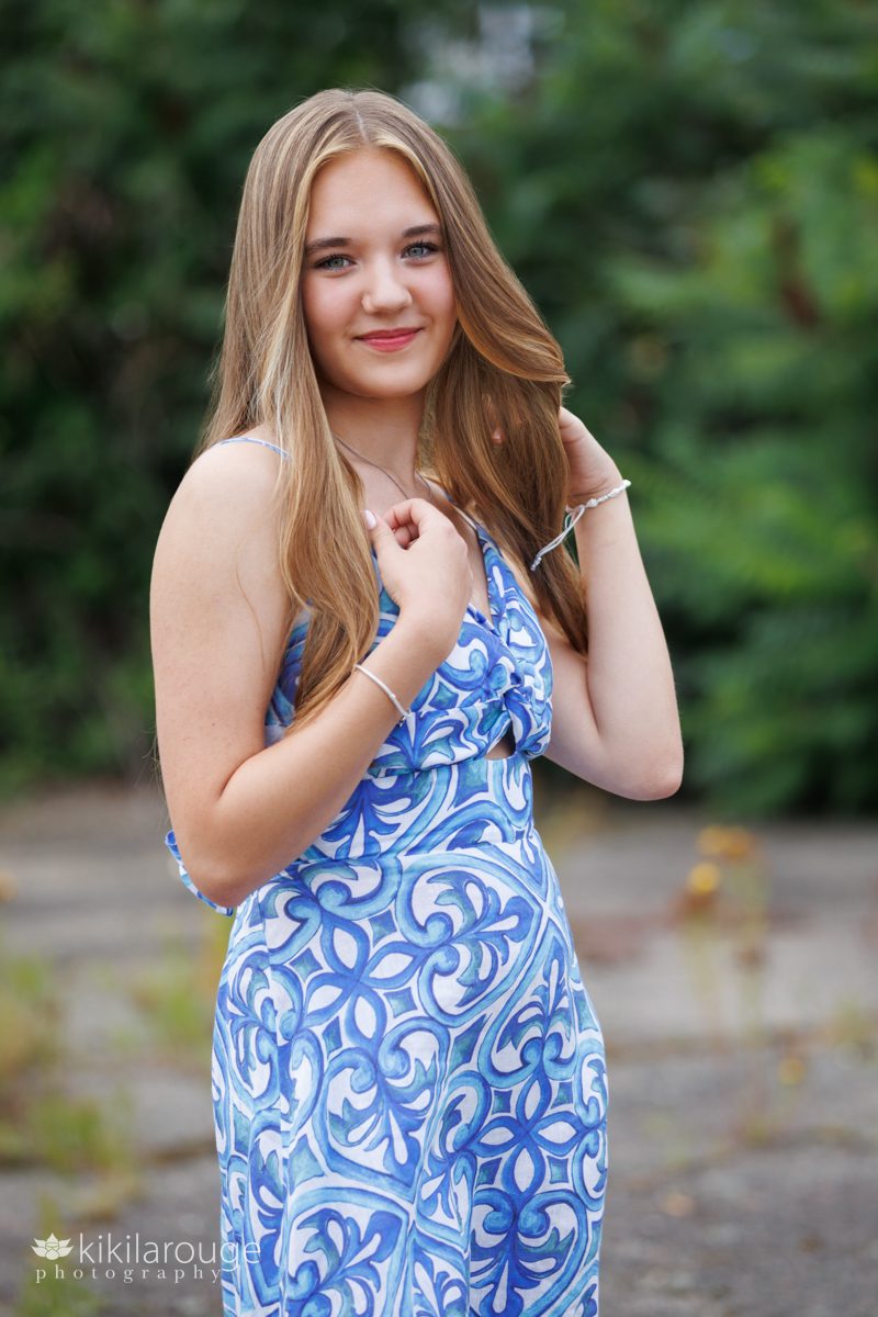 Senior portrait girl in blue and white dress green backdrop