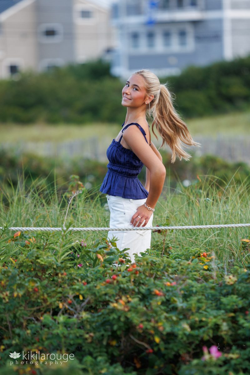Senior girl with long blonde hair in a pony tail in beach dunes at Plum Island